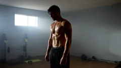 Muž s vypracovaným svalstvem ve fitku při silovém tréninku, sportovní postava.