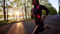 Žena běží v parku za svítání, sportovní oblečení, zdravý životní styl, ranní běh